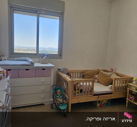 חדר ילדים עם מיטת תינוק, עגלת בובה וארון מגירות